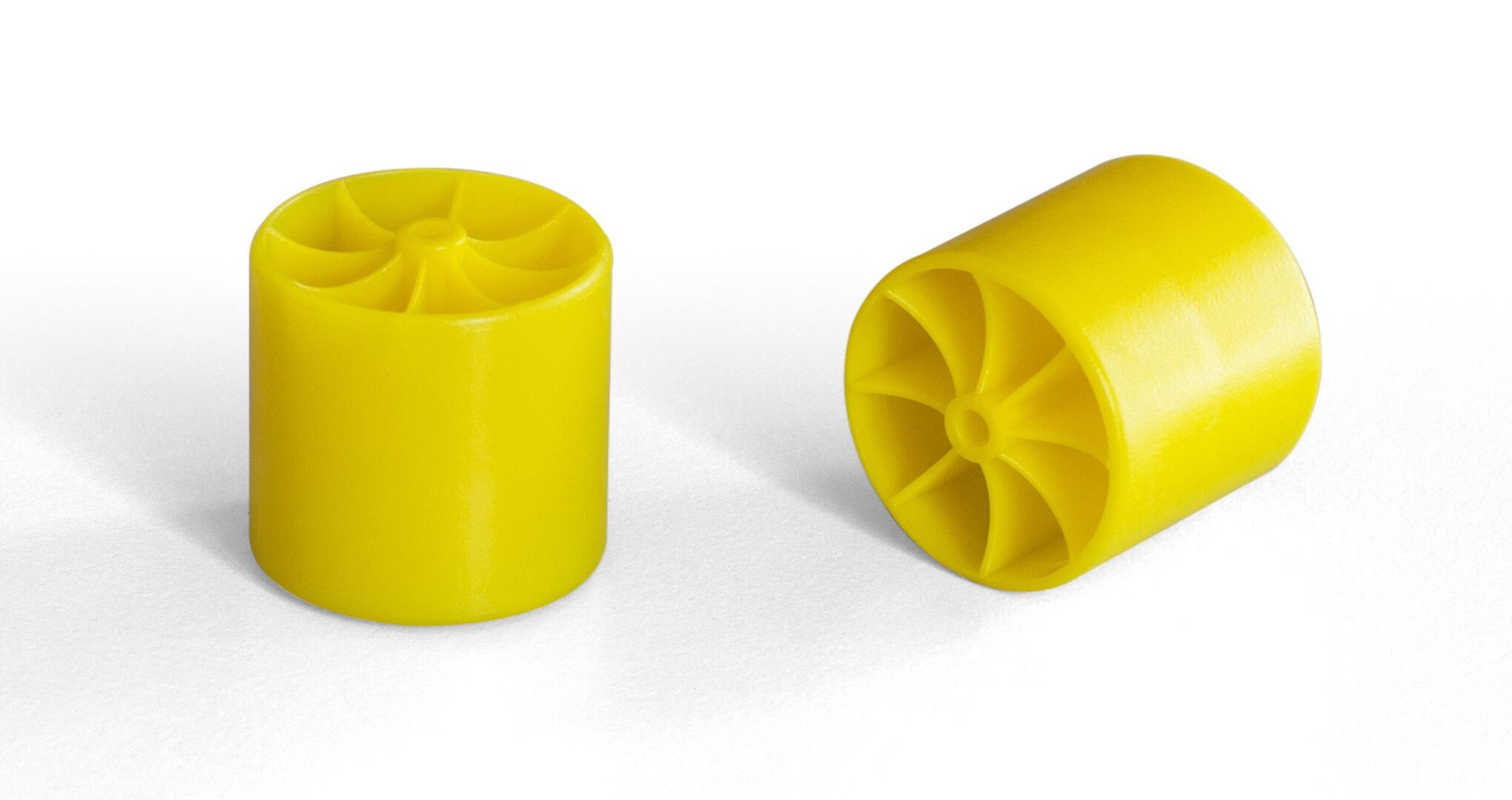 Two yellow cylindrical rollers with eight-spoke star-shaped internal patterns, one standing upright and the other lying on its side.