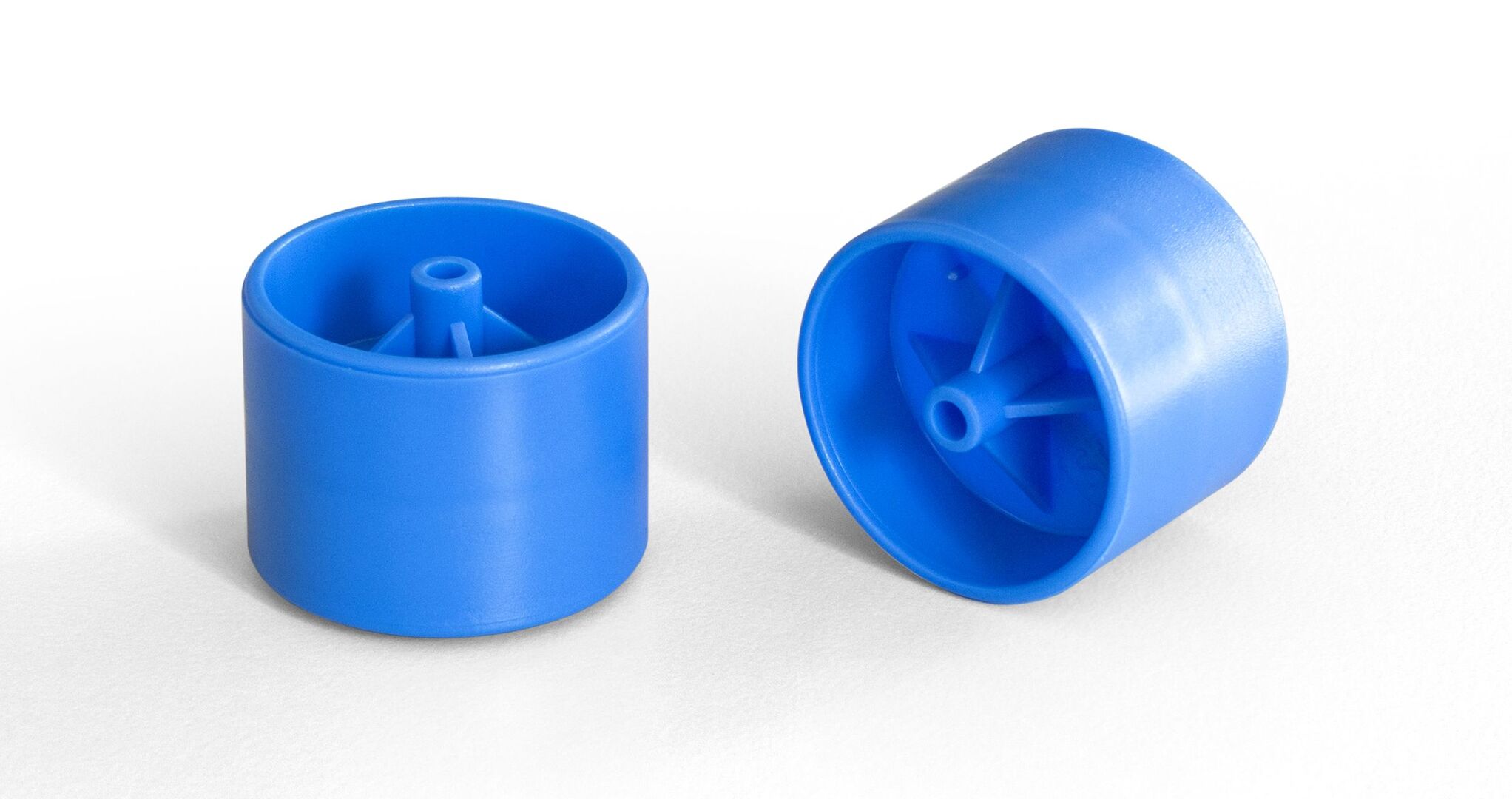 Two blue cylindrical plastic rollers with central spokes, one upright and one lying on its side.